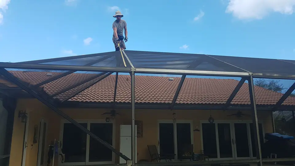 Person standing on the aluminum frame of a pool cage