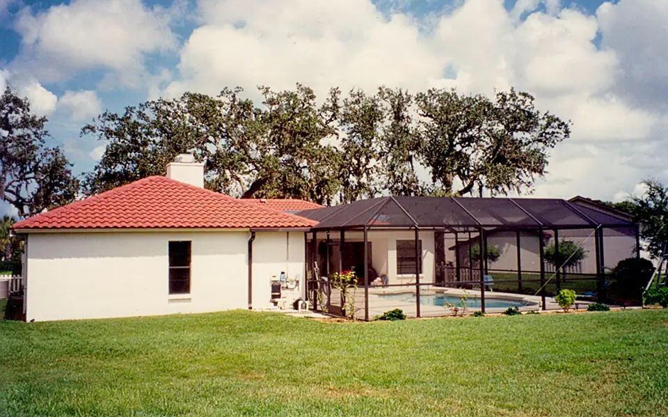 Florida home with a screened pool cage behind it